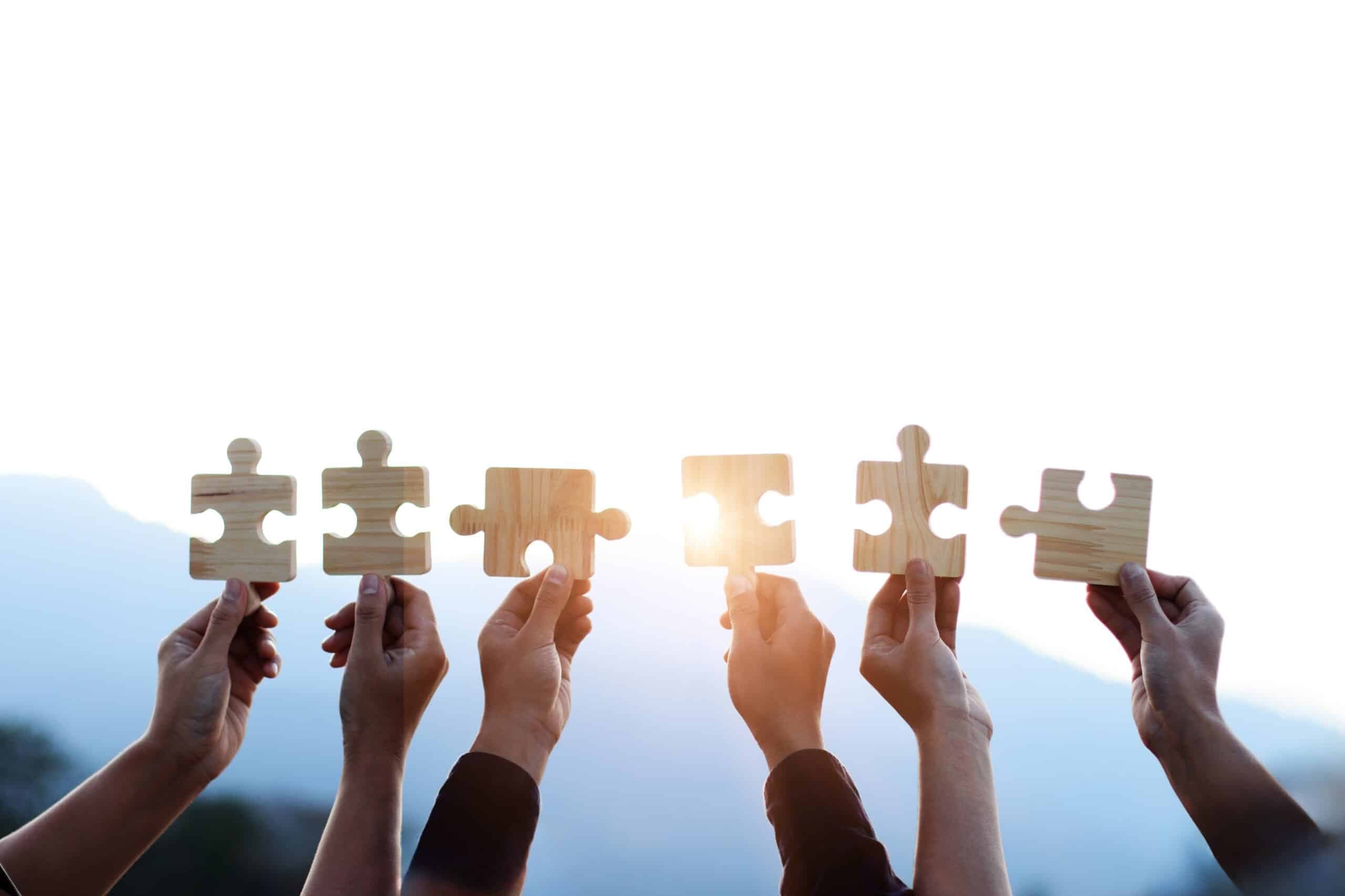 Teamwork,And,Partnership,Concept.,Hands,Are,Raised,Against,A,Bright,